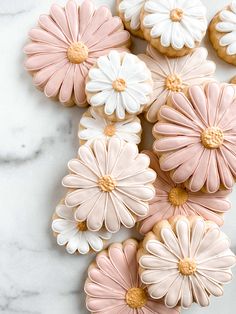 cookies decorated with pink and white flowers are displayed on a marble table top for an instagram