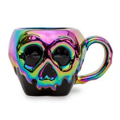 a glass cup with a skull design on the front and sides, painted in multi - colored holographics