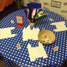 a blue table with white polka dots and paper cutouts on it