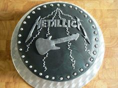 a cake with the word metallic on it and an image of a guitar in the middle