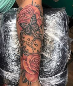 a tattoo with roses and a clock on it