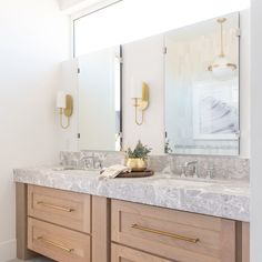 a bathroom with double sinks and two mirrors