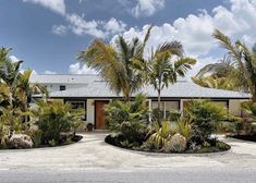 a house with lots of palm trees in front of it