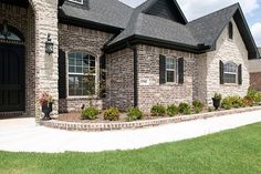 a brick house with black shutters and windows