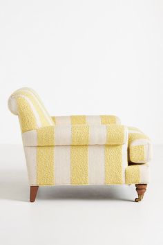 a yellow and white striped chair with wooden legs