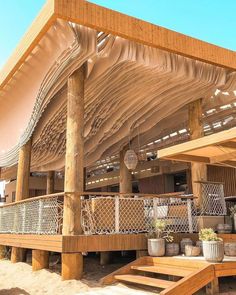 an outdoor covered patio with wooden steps and potted plants