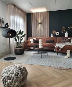 a living room filled with lots of furniture next to a wall mounted lamp and window