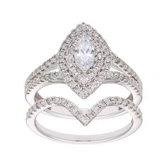 a white gold ring set with an oval shaped diamond and two rows of diamonds on each band