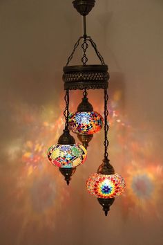 three colorful lights hanging from a chandelier