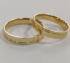 two gold wedding rings on a white background