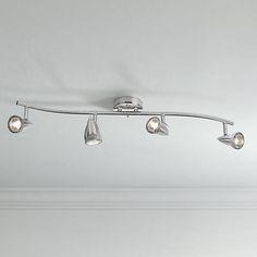 three lights are hanging from the ceiling in a room with white walls and flooring