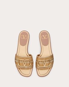 Valentino Garavani slide sandal in laminated nappa leather with Cornely embroidery and VLogo Signature decoration - VLogo Signature accessory in light gold finish - Heel height: 5 mm / 0.2 in. - Made in Italy Luxury Gold Mules For Spring, Designer Gold Open Toe Sandals, Elegant Gold Leather Slides, Luxury Gold Sandals For Summer, Elegant Gold Flat Slides, Elegant Gold Slides For Spring, Luxury Gold Leather Sandals, Designer Gold Sandals For The Beach, Elegant Gold Open Toe Slides