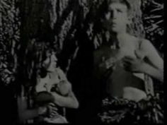 black and white photograph of two women sitting in front of trees, one holding a baby