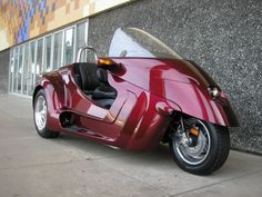 a red motorcycle parked next to a building