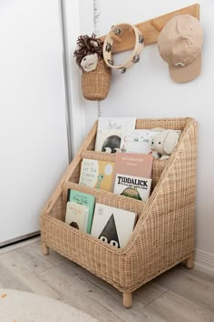 a wicker basket with books in it sitting on the floor next to a door