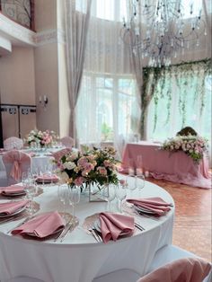 the table is set with pink napkins and place settings