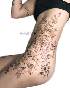 a woman's thigh with flowers and leaves on the side, as well as her lower leg