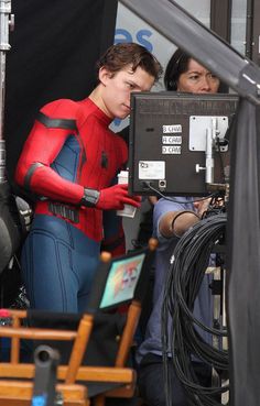 the spider - man is being filmed by two people