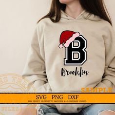 a woman wearing a sweatshirt with the letter b in santa's hat on it