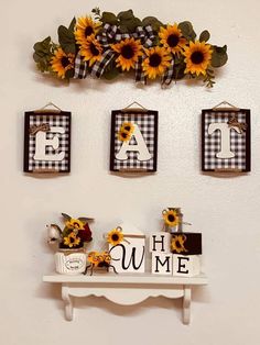 three sunflowers are hanging on the wall above a shelf with letters and frames