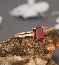 a red stone ring sitting on top of a rock