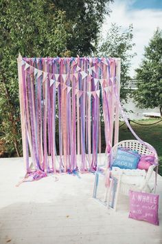 a chair sitting on top of a wooden floor next to a pink and purple curtain