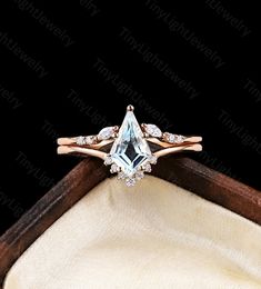 an engagement ring with a blue topazte surrounded by white diamonds in a wooden box