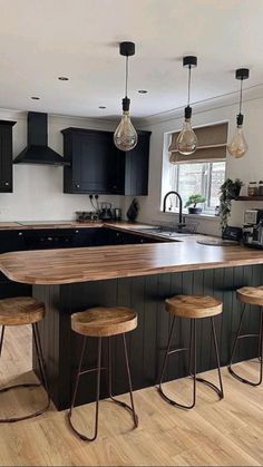 a kitchen with black cabinets and wooden counter tops