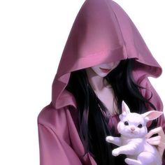 a woman holding a white cat in her hands and wearing a pink hooded jacket with long black hair