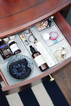 an open drawer on a table with various items in it and some other things inside