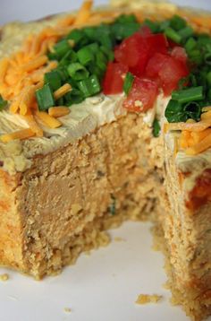 a close up of a cake with cheese and vegetables on it's top slice