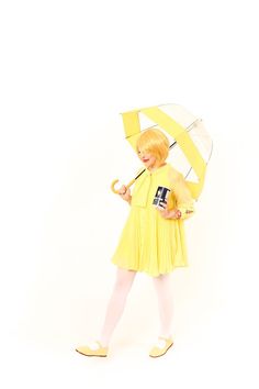 a woman in yellow dress holding an umbrella