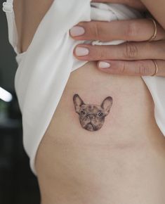 a small dog tattoo on the back of a woman's stomach