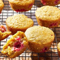 muffins cooling on a wire rack with raspberries in the middle and one half eaten