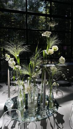 there are many vases with flowers in them on the table