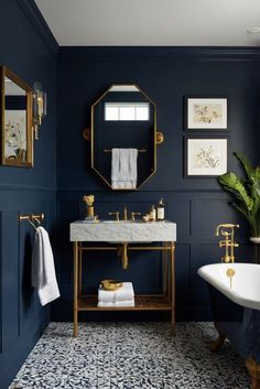 a bathroom with blue walls, gold fixtures and a white tub in the middle of it