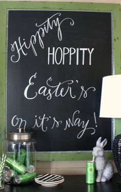 a chalk board with writing on it next to a lamp