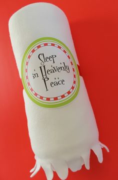 a roll of toilet paper with the words sleep in heavenly peace printed on it, sitting on a red surface