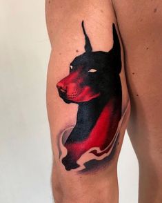 a man's leg with a tattoo of a dog on it, which is red and black