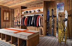 a snowboard and ski equipment in a room with wood paneling on the walls