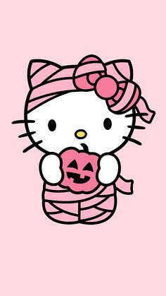 hello kitty holding a pumpkin on a pink background