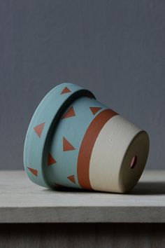 a roll of toilet paper sitting on top of a wooden table next to a gray wall