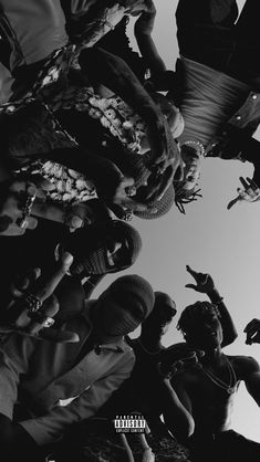 a group of people standing next to each other with their hands in the air and looking up