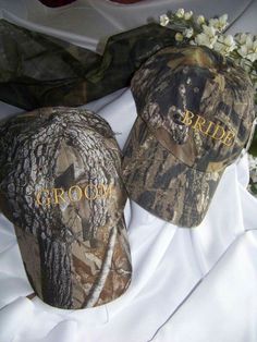 two hats with the word bride and groom written on them sitting on a white table cloth