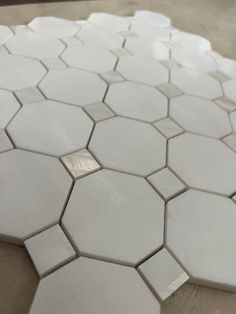 white hexagonal tiles are arranged on the floor