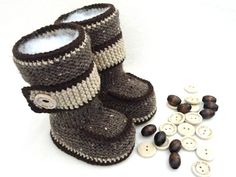 a pair of knitted baby shoes next to buttons on a white background with the caption pattern 29