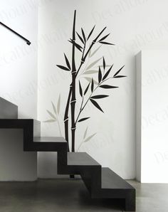 a black and white photo of a bamboo plant on the wall next to some stairs