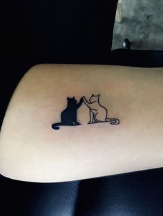 a cat and mouse tattoo on the back of a woman's left arm,