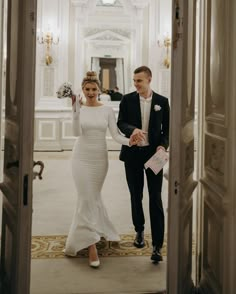 a bride and groom walk through the doorway to their wedding ceremony in an ornate building