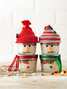 three jars with snowmen in them sitting on a table